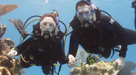 HHUC buddy pair holding hands on a coral reef